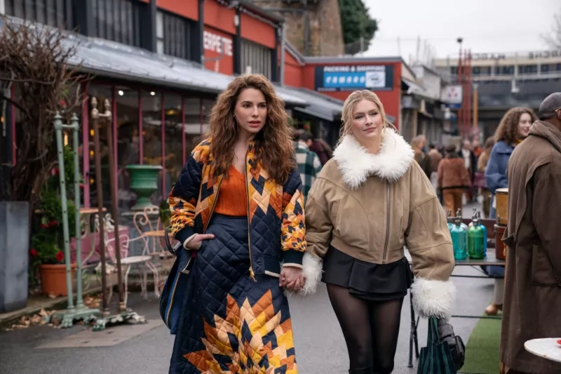 A pair of women walking through a street market in fall