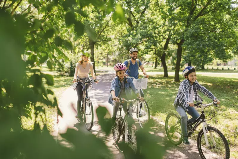 Family cycling on a path surrounded by trees