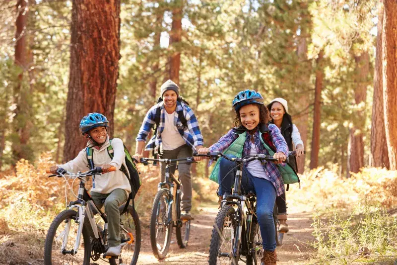 Family cycling through forest