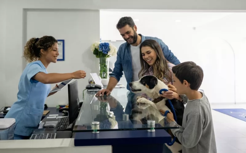 Happy family taking their dog to the vet stock photo