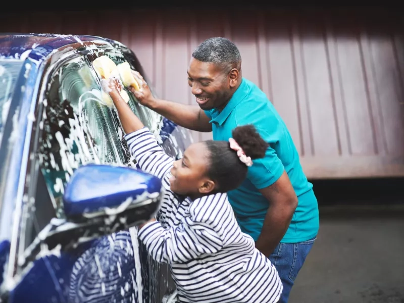 ather and his daughter washing their car outside