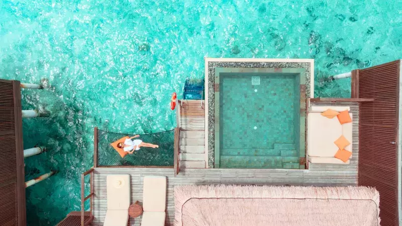 woman lying on hammock over ocean in Maldives