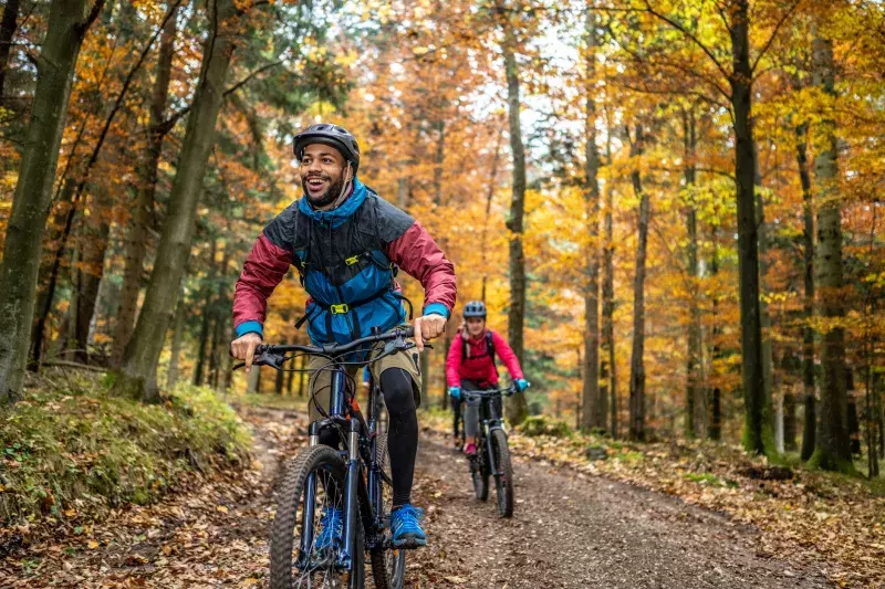 Man and woman riding mountain bikes in forest