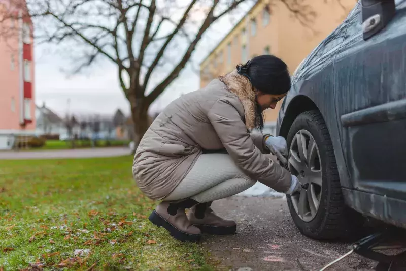 woman changing car tires