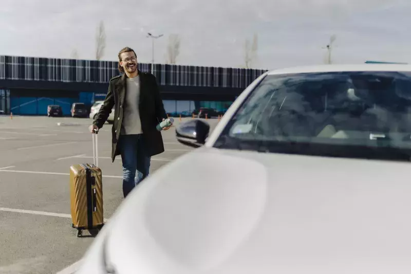 man in the airport walking towards rental car