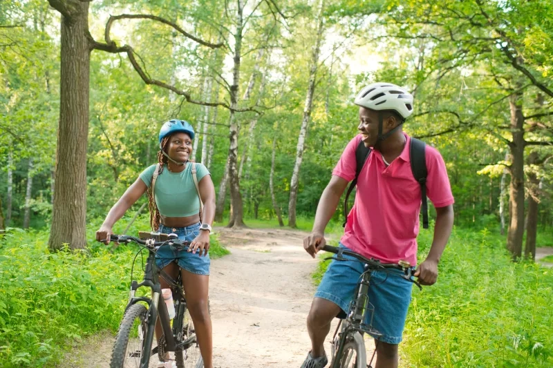 Young couple riding bicycle in summer park