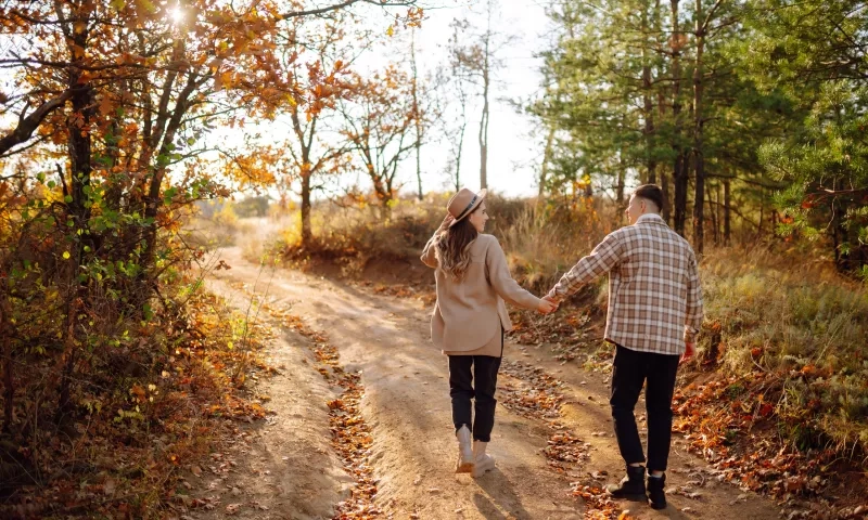 A couple enjoys a joyful moment together on a serene autumn day