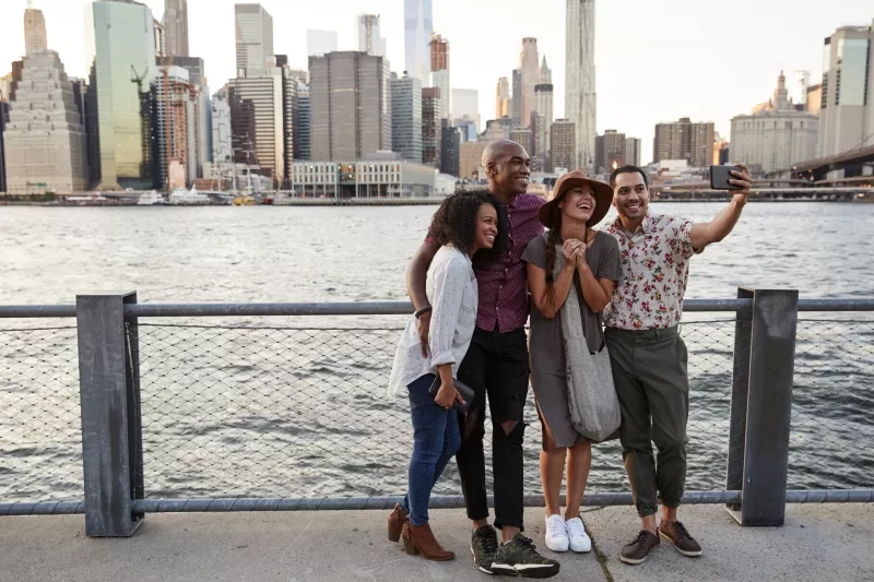 Group of friends posing for selfie in front of manhattan skyline