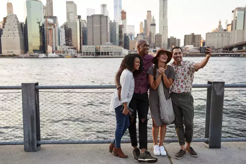 Group of friends posing for selfie in front of manhattan skyline