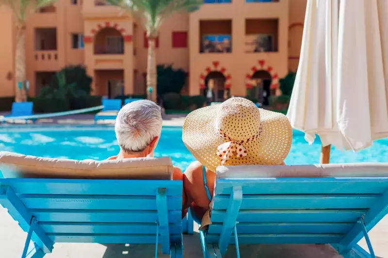 enior couple relaxing by swimming pool