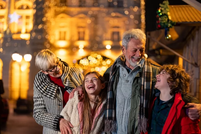 Happy grandparents enjoying the evening walk laughing together with young grankids.