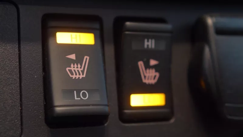 Heated car seat switches being toggled to control seat warmers