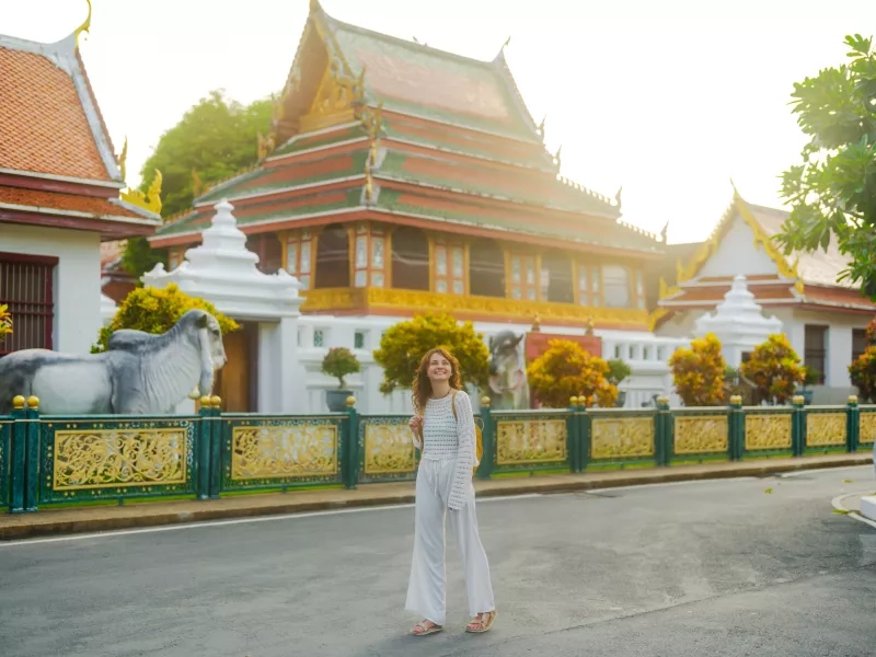  woman with backpack exploring temple in Bangkok