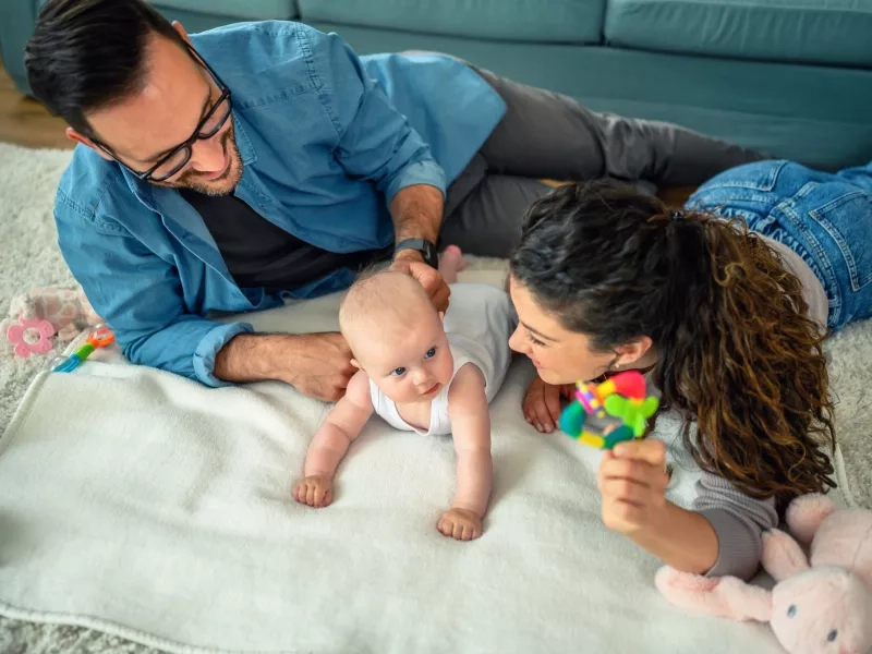 young parents playing with their baby girl at home