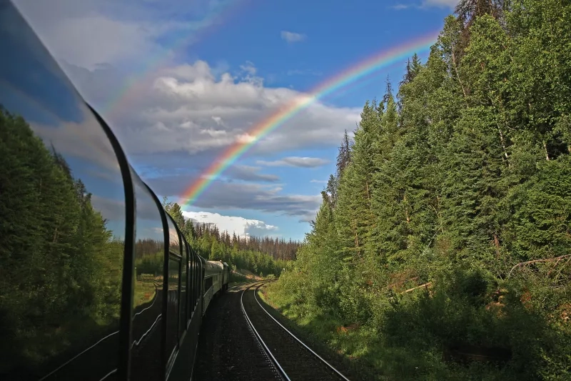 Train with rainbow in sky