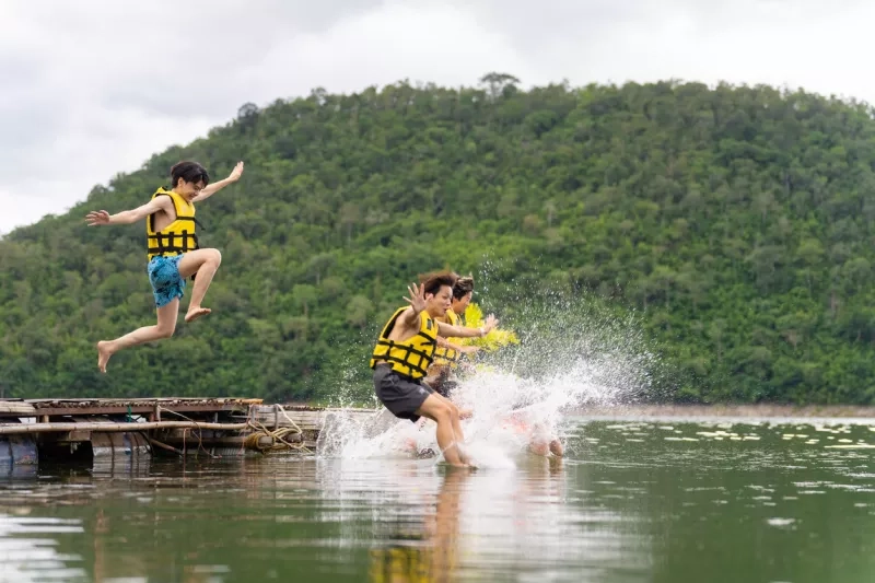 people jumping in a lake