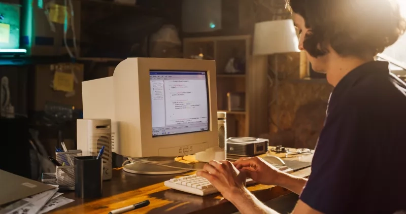 person typing at old computer