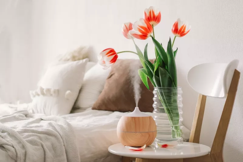 oil diffuser on chair next to bed