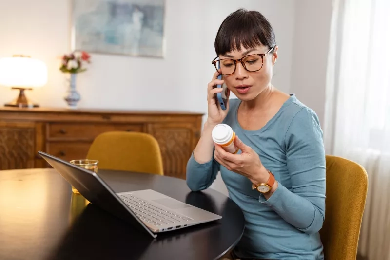 woman reading pill bottle instructions