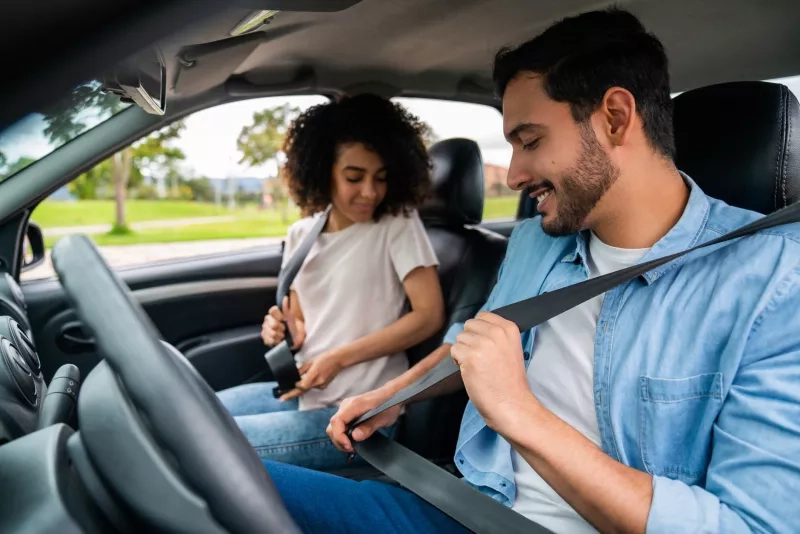 Couple in a car fastening their seat belts