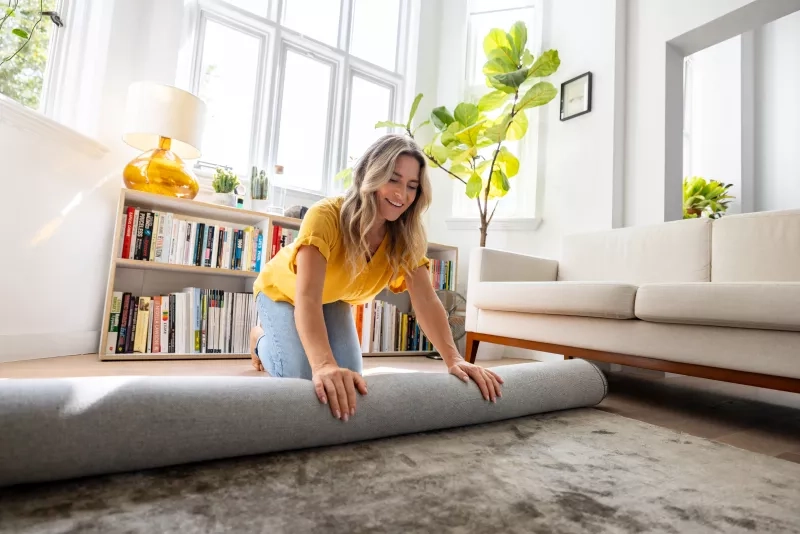 women rolling a rug