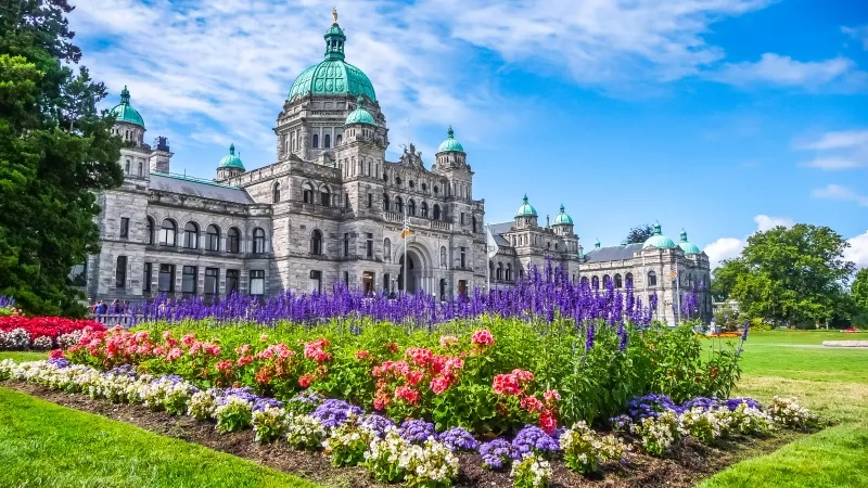 Historic parliament building in Victoria with colorful flowers, BC
