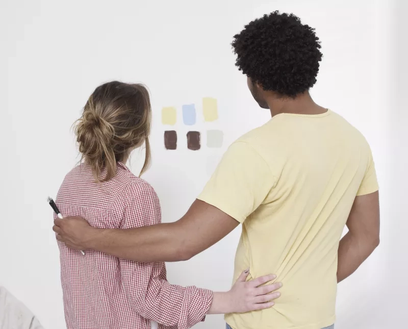 Couple looking at paint swatches on a wall