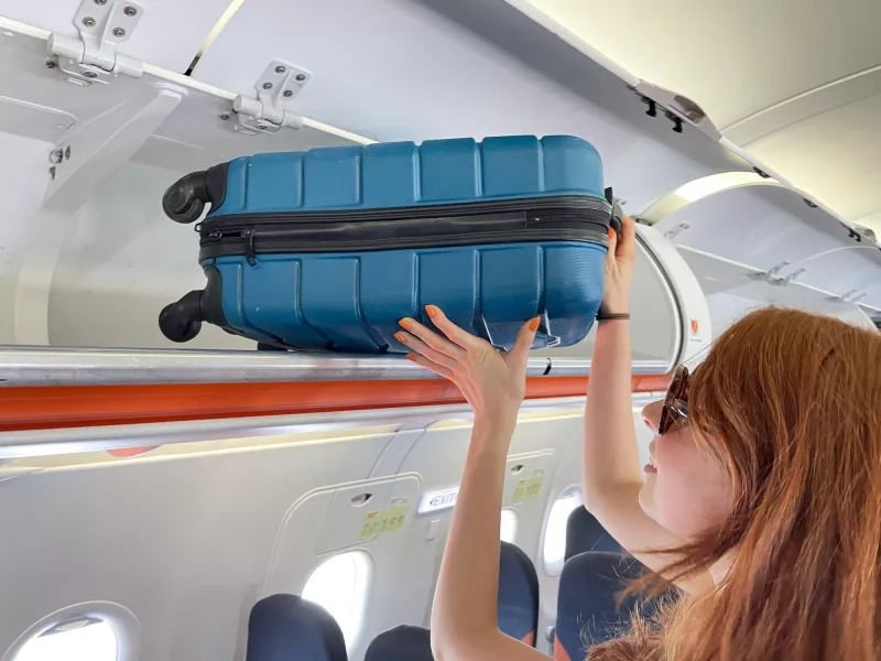 place carry on luggage in overhead bin