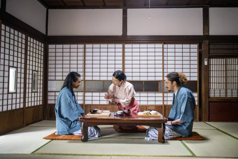 Japanese server dressed in kimono delivering a meal to guests at a traditional Tokyo ryokan