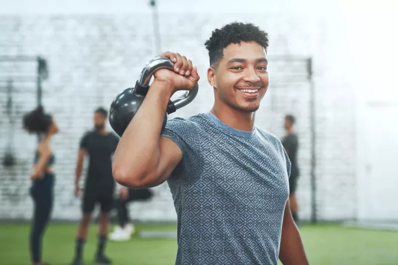 man exercising with a kettlebell in a gym