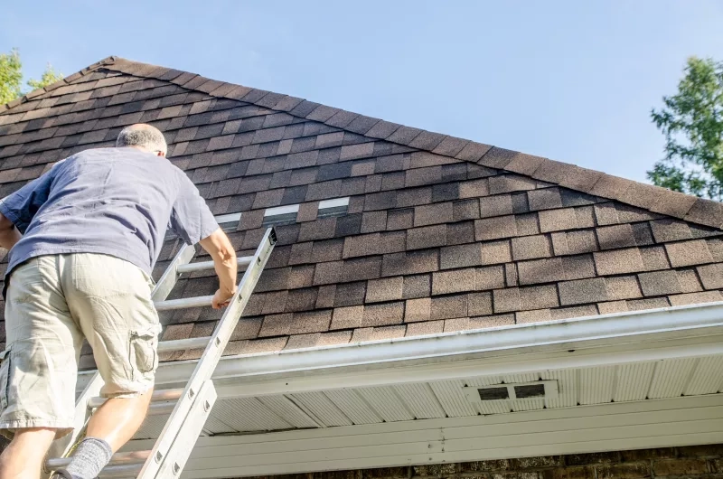 man repairing asphalt shingle roof 