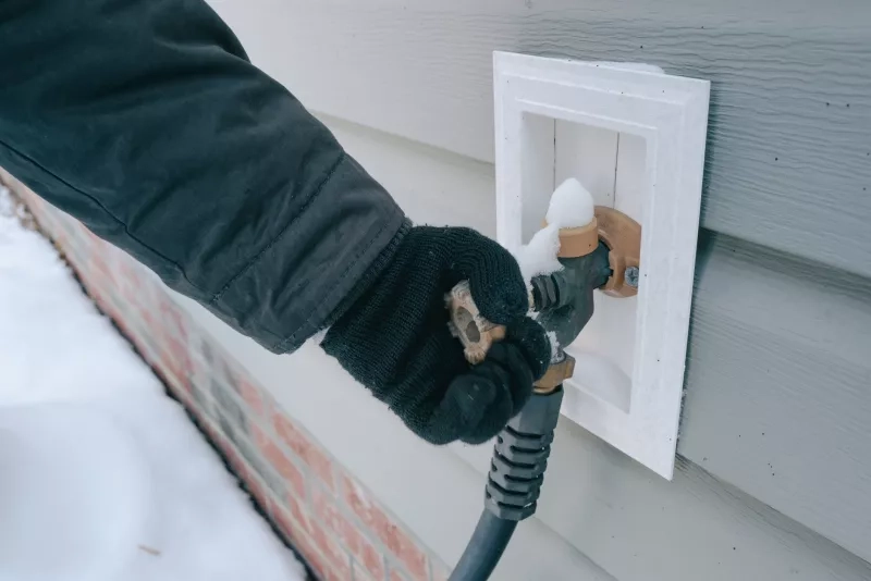Woman Checking Frozen Outdoor Water Faucet
