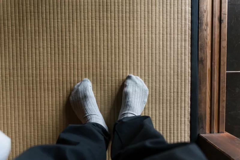 feet in socks standing on a tatami mat