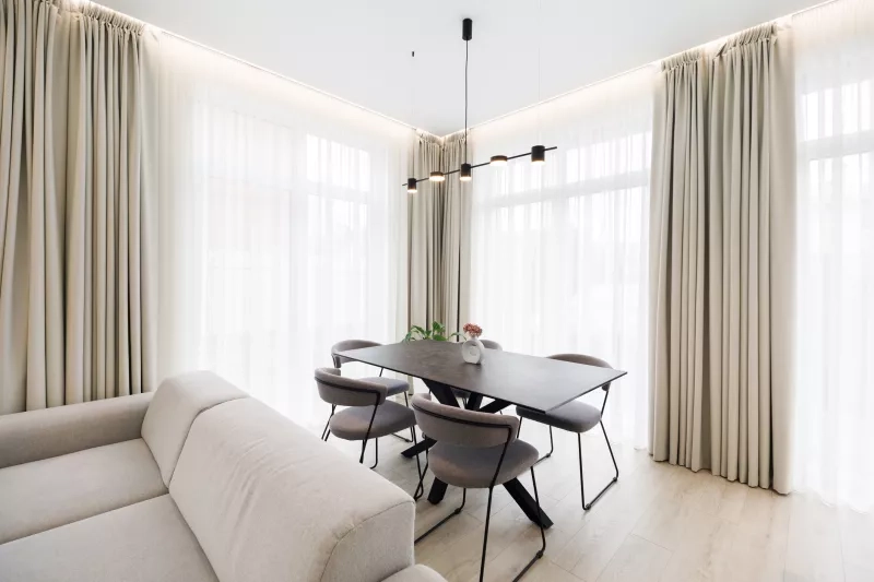 Dark wood dinning room table with wall of windows behind