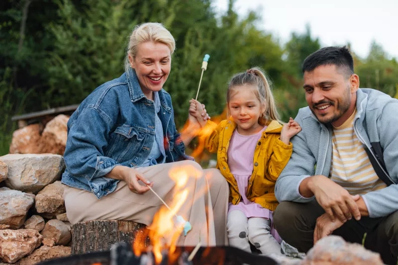 Family Enjoying Campfire While Roasting Marshmallows Outdoor