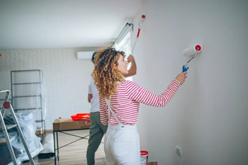 Couple painting wall together