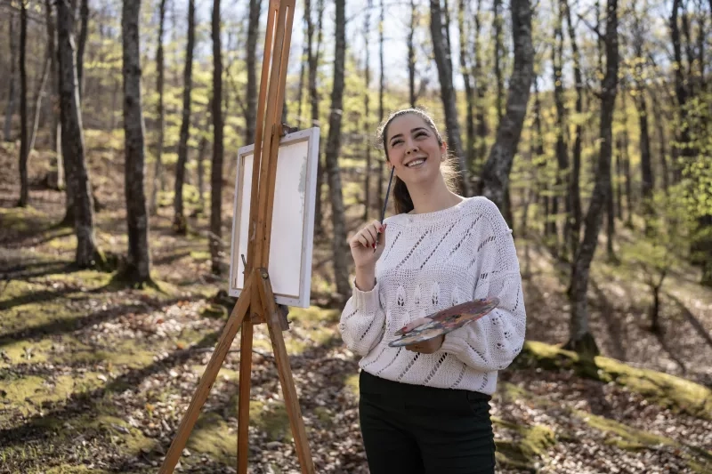 woman painting in forest