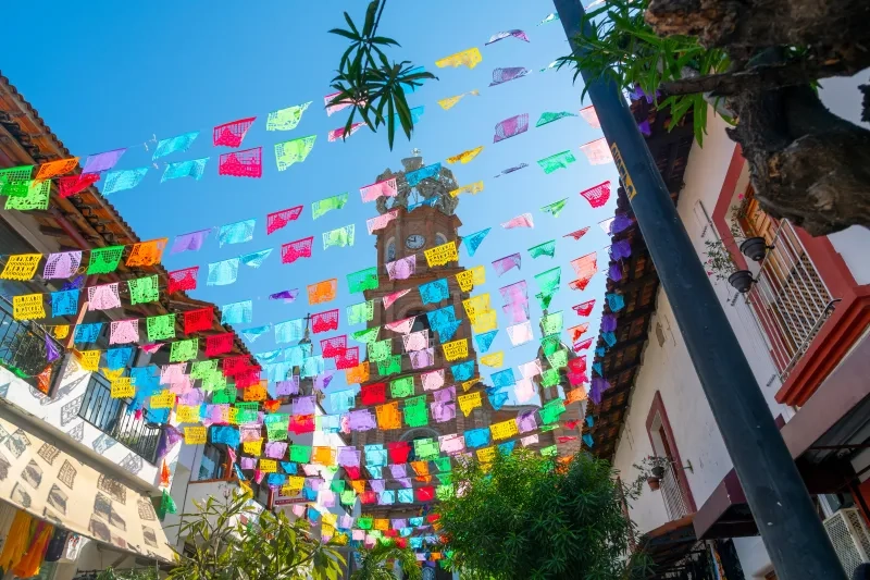 Lady of Guadalupe with colorful flags strung across the street on a sunny morning in Puerto Vallarta
