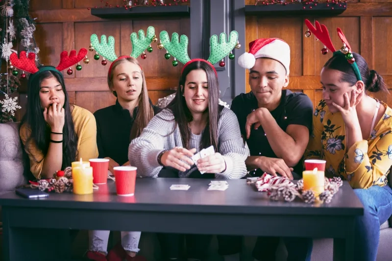 A group of people playing a card game at Christmas