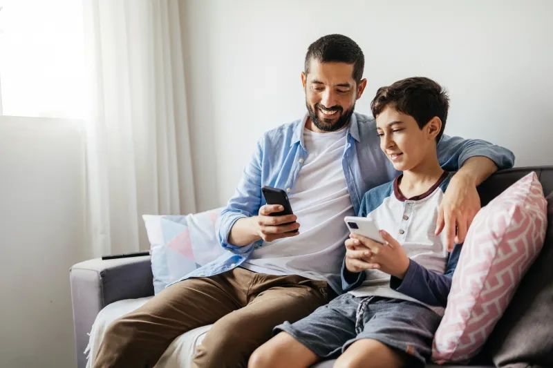 Father and son looking at their phones