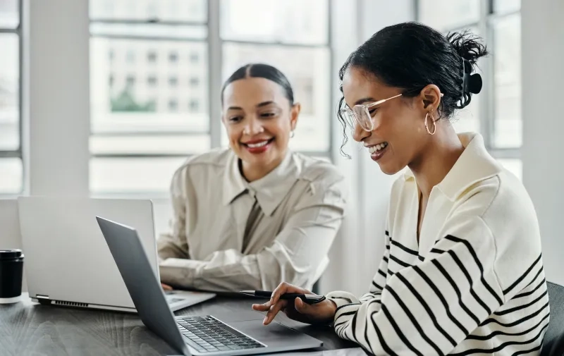 Two women working on their laptops