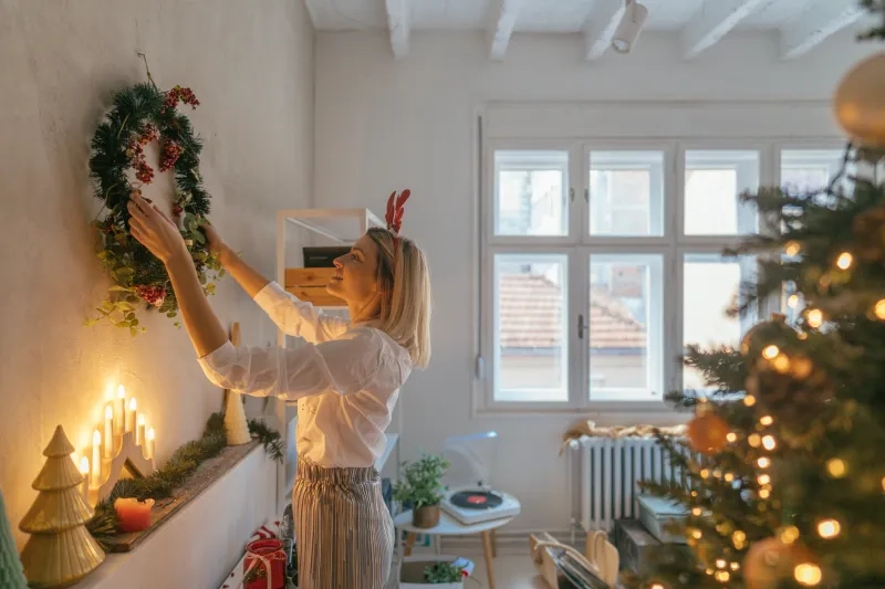 woman hanging a Christmas wreath