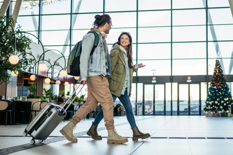 Two people walking in airport during Christmas season 