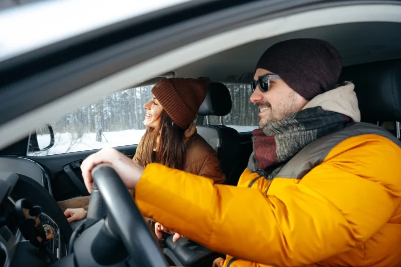 couple sitting in car in winter clothes