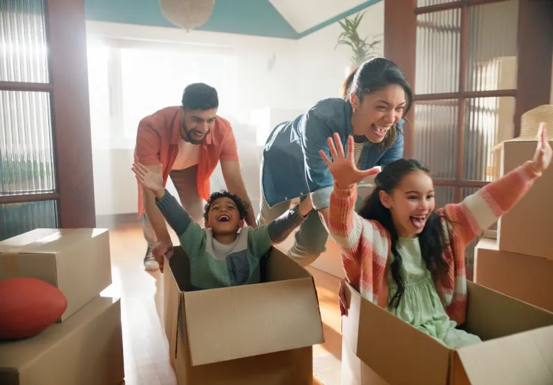 Happy family, parents and children in boxes in new home or playing game
