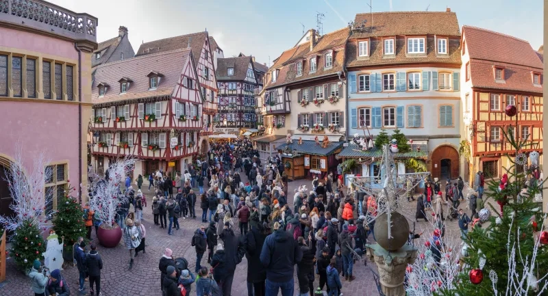 Tourists visiting christmas market in Colmar, France 