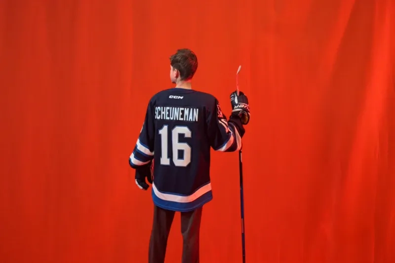 A young teen boy poses with his back to the camera in a hockey jersey for a promo for the 2026 sens skills junior draft