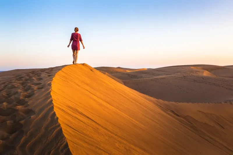 Woman walking on sand dunes