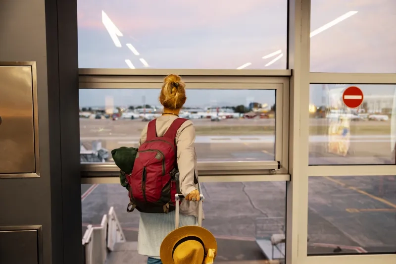 Woman at airport looking out of window