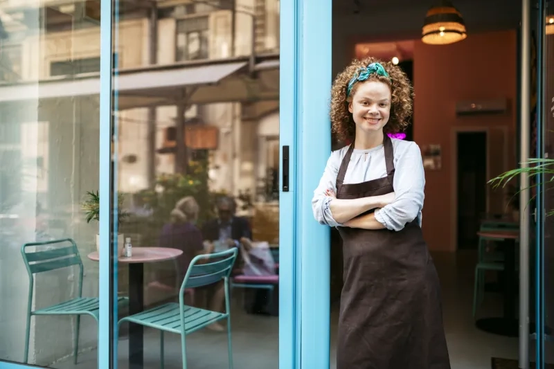store owner standing outside cafe